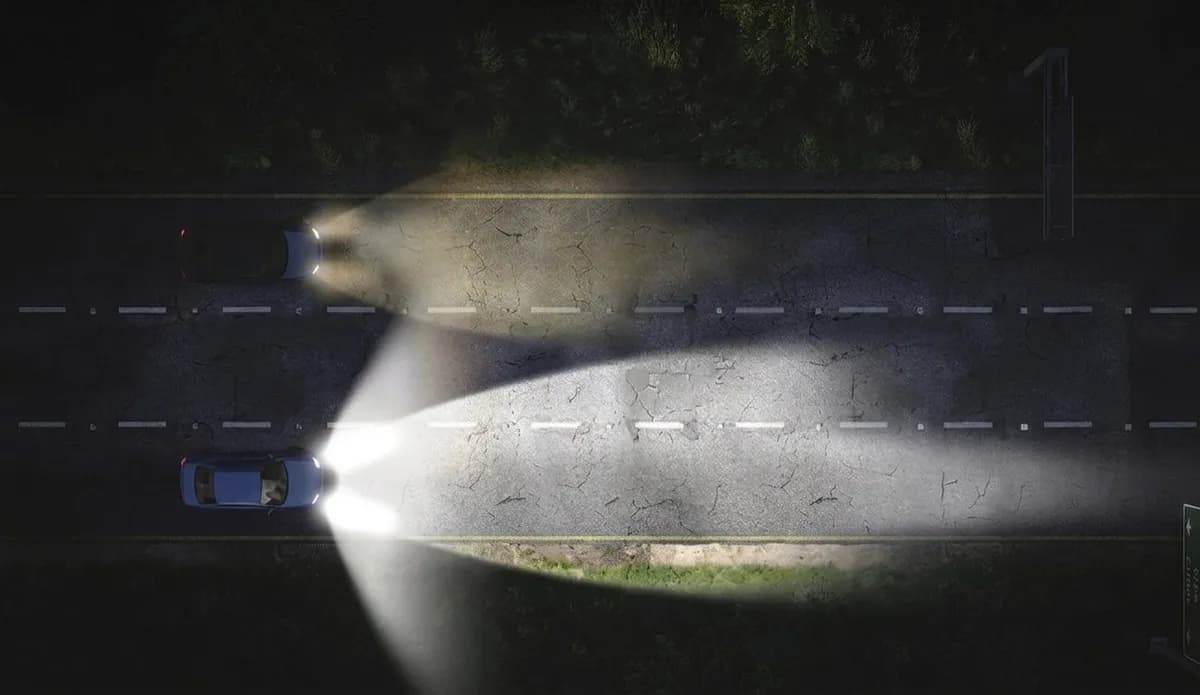 Top-down comparison of headlight beam distance before and after restoration — restored headlights illuminate the road much farther at night